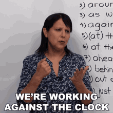 a woman stands in front of a white board with the words " we 're working against the clock "