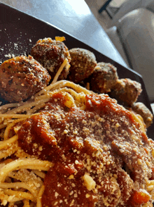 a plate of spaghetti with meatballs and sauce on a table