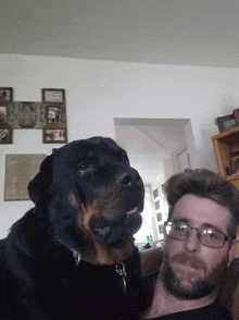 a man and a dog are posing for a picture in a living room with a sign that says " i love you "