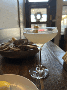 a martini glass with a lemon peel on top of it