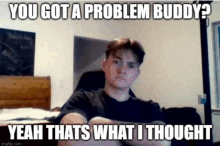 a young man is sitting on a couch with his arms crossed and a meme .