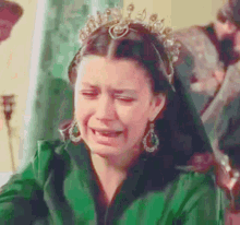 a woman wearing a tiara is crying