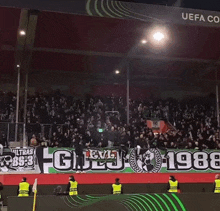 a crowd of people watching a soccer game with a banner that says uefa