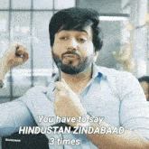 a man with a beard is holding a pen in his hand and says you have to say hindustan zindabad 3 times