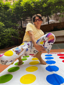 a man is kneeling on a twister board outside