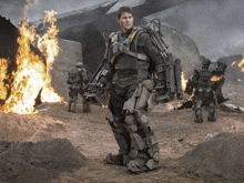 a man in a robotic suit is standing in front of flames