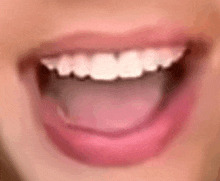 a close up of a woman 's mouth with her tongue out and her teeth showing .