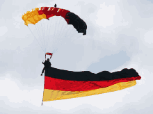 a man is flying a german flag with a parachute attached to it