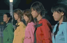 a group of people are standing in a line and one of them is wearing a red jacket