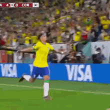 a soccer player is running on the field in front of a visa ad