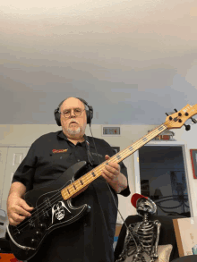 a man wearing headphones holds a bass guitar