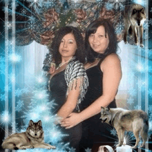 two women are posing for a picture with wolves and a candle in the background .