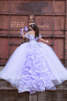 a woman in a purple dress holds a bouquet of flowers in front of a sign that says close & lock