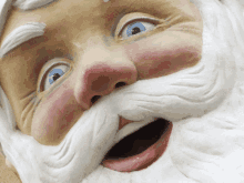 a statue of santa claus with a white beard and blue eyes