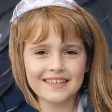 a young girl wearing a purple headband and smiling