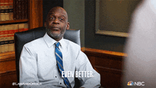 a man in a white shirt and blue tie is sitting in a chair with the words " even better " above him