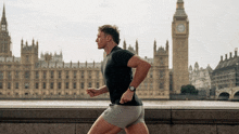 a man wearing a watch is running in front of a big ben clock tower