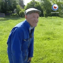 a man in a blue jacket and hat is standing in a grassy field with an omrop fryslan logo on the bottom