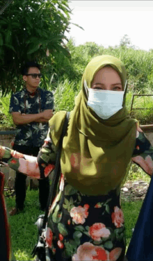 a woman wearing a mask and a green hijab