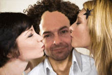 two women kissing a man on the cheek with a star in her hair