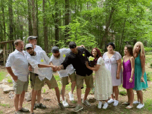 a group of people posing for a picture with a bride and groom holding hands