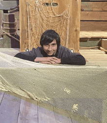 a young boy is leaning on a fishing net