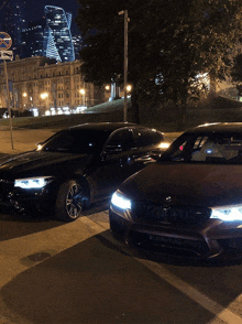 two black cars are parked next to each other on a city street