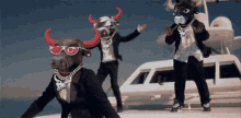 a group of men dressed as bulls are dancing in front of an airplane