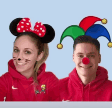 a woman wearing minnie mouse ears and a man wearing a jester 's hat