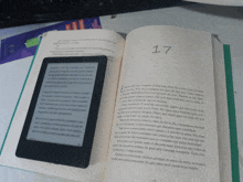 a book is open to page 17 and a tablet is sitting on top of it