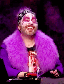 a man wearing a purple fur coat with a screaming face on it