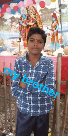 a boy in a blue shirt stands in front of a statue with the words " my brother " written on the bottom