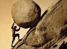 a man is carrying a large rock up a hill .