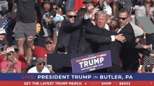 a man holding a sign that says trump stands in front of a crowd