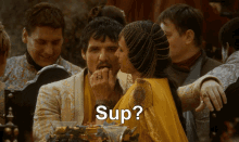 a group of people are gathered around a man and a woman and the word sup is visible