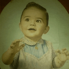 a baby is wearing a striped shirt and blue shirt