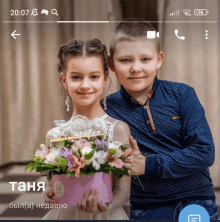 a boy and a girl are posing for a picture and the girl is holding a bouquet of flowers