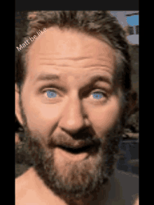 a shirtless man with a beard and blue eyes is making a funny face