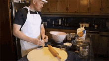 a man in an apron is preparing food in a kitchen with a bag of gold enriched flour on the counter