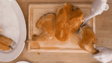 a person is cutting a turkey on a cutting board with the number 52 on the bottom right