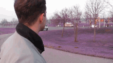 a man stands in front of a purple field with a white van that says ' ice cream ' on it