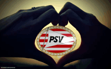 a person is making a heart shape with their hands with the psv logo on it