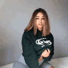 a woman wearing a green carhartt sweatshirt