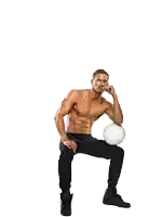 a shirtless man sits with his hand on his chin while holding a white volleyball