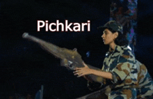 a woman in a military uniform is holding a gun in front of a sign that says pichkari