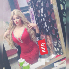 a woman in a red dress is standing in front of a mirror with a sign that says kitty on it