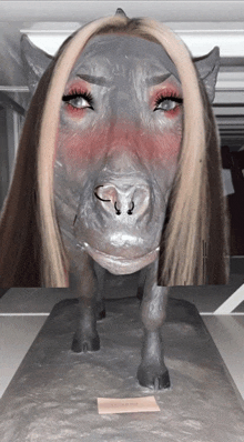 a statue of a pig with a woman 's face painted on