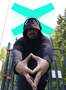 a man wearing headphones and a black hoodie is kneeling down