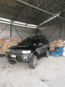 a black truck with a license plate that says gs bet sits in a warehouse