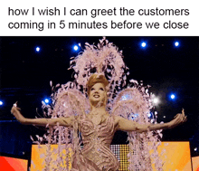 a drag queen in a pink dress with feathers coming out of her wings